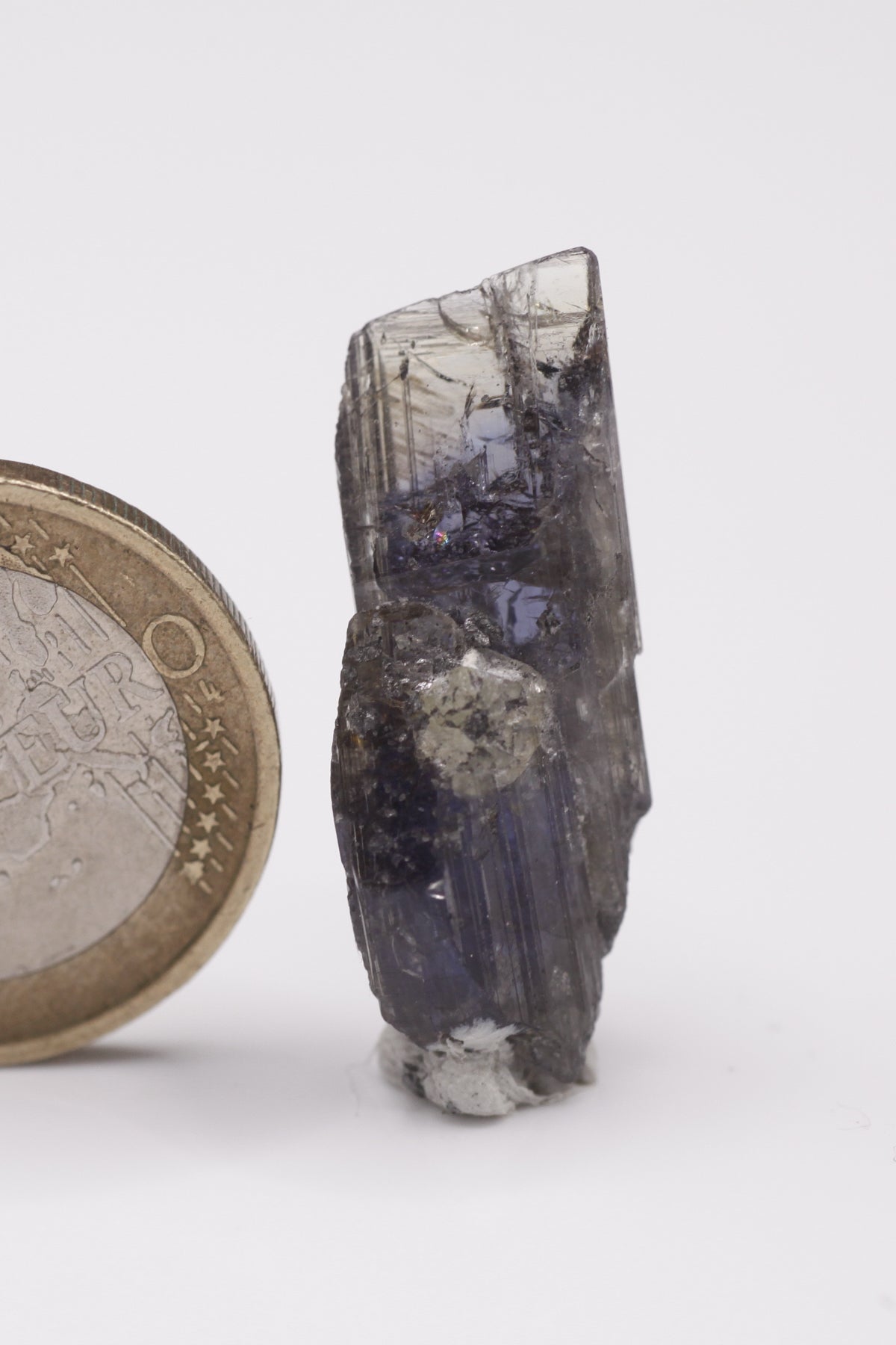 Tanzanite - Mine Mineral Market : A009 Ein violetter Doppelender mit sehr guter Endfläche oben und gutem Pleochroismus, seitlich in einem kleinen Bereich etwas Graphit aufsitzend.