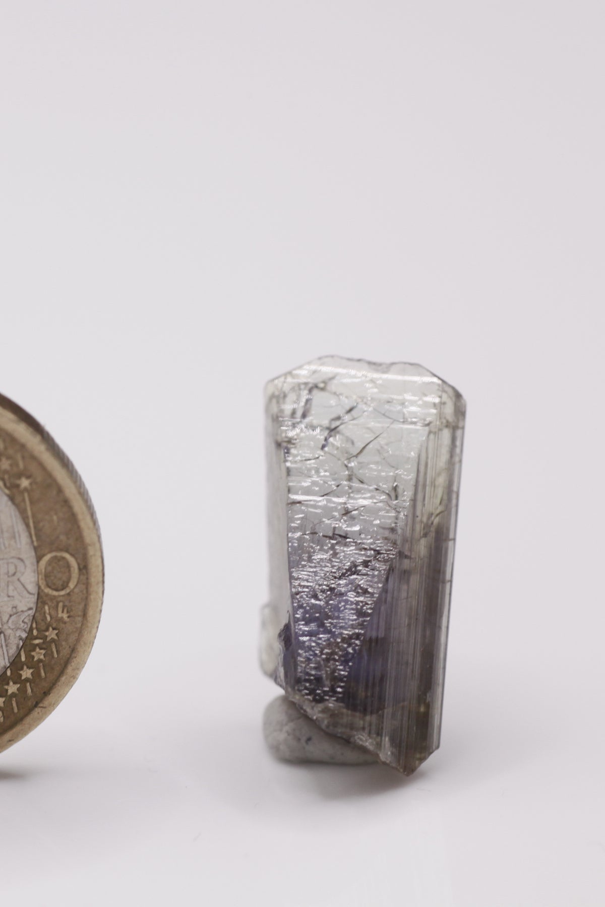 Tanzanite - Mine Mineral Market : A011 Ein nahezu klarer Tansanit mit sehr gutem Pleochroismus. Eine abgebrochene Seite ist wieder verheilt.