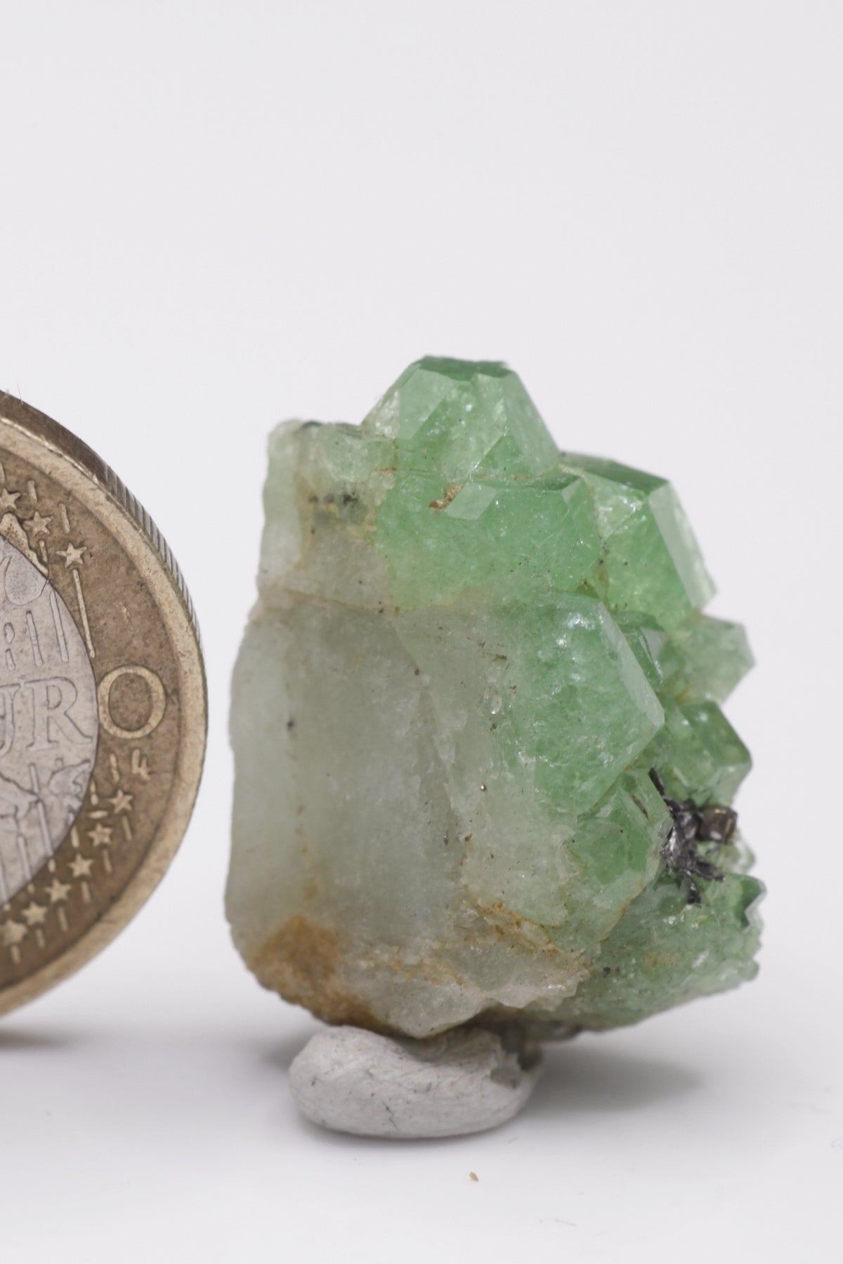 Tsavorite - Mine Mineral Market : A061 Eine kleine Stufe von Tsavorit-Kristallen mit gutem Glanz. In einer kleinen Höhle sitzen Graphitkristalle.