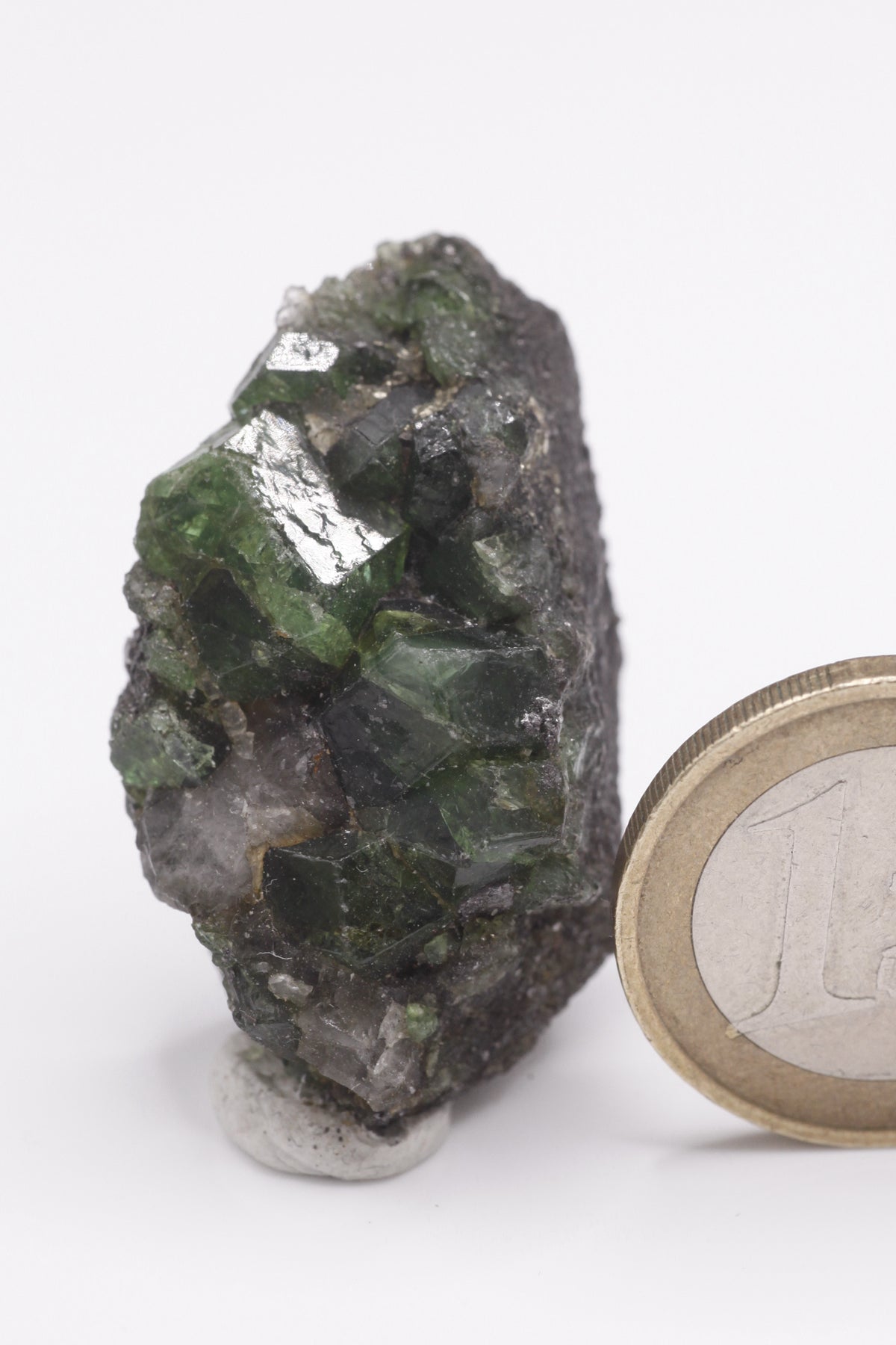 Tsavorite - Mine Mineral Market : A072 Ein großer dunkler Tsavoritkristall mit etwas Graphit und recht gutem Glanz.