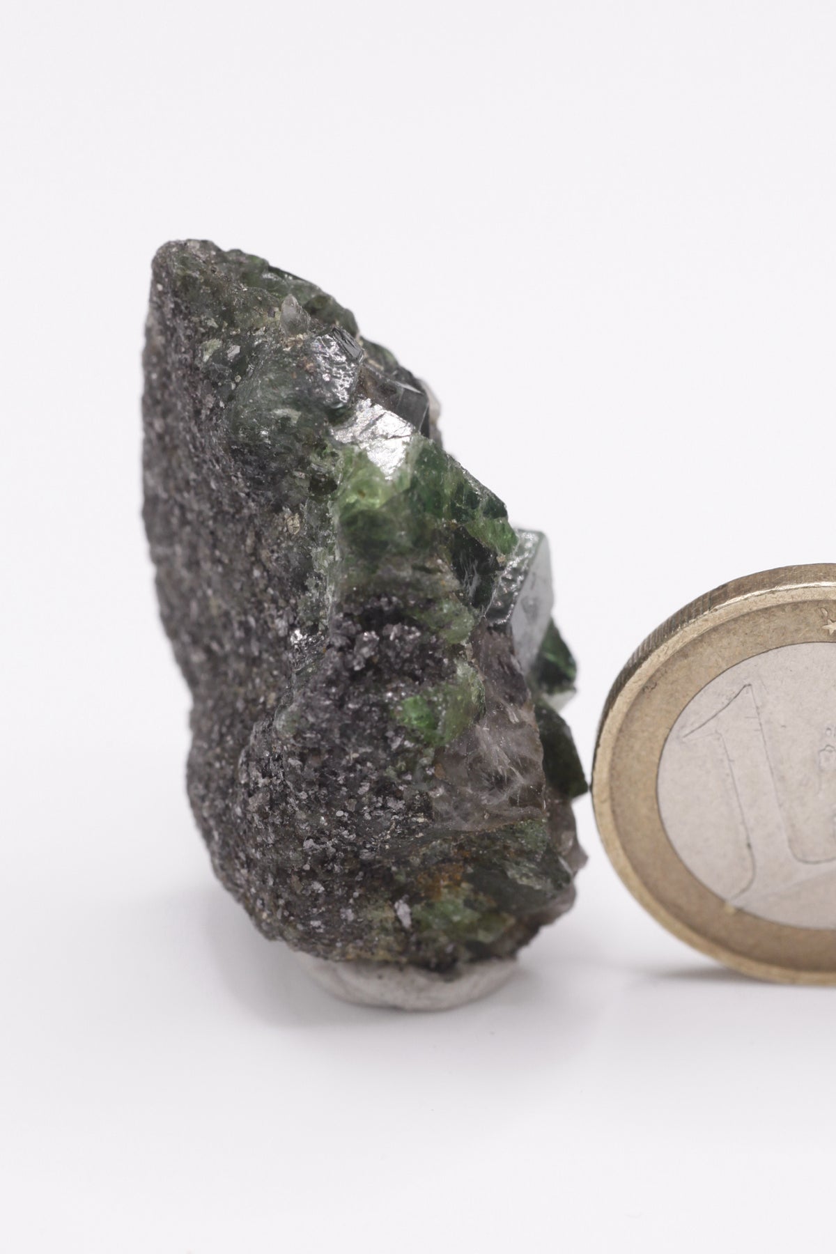 Tsavorite - Mine Mineral Market : A072 Ein großer dunkler Tsavoritkristall mit etwas Graphit und recht gutem Glanz.