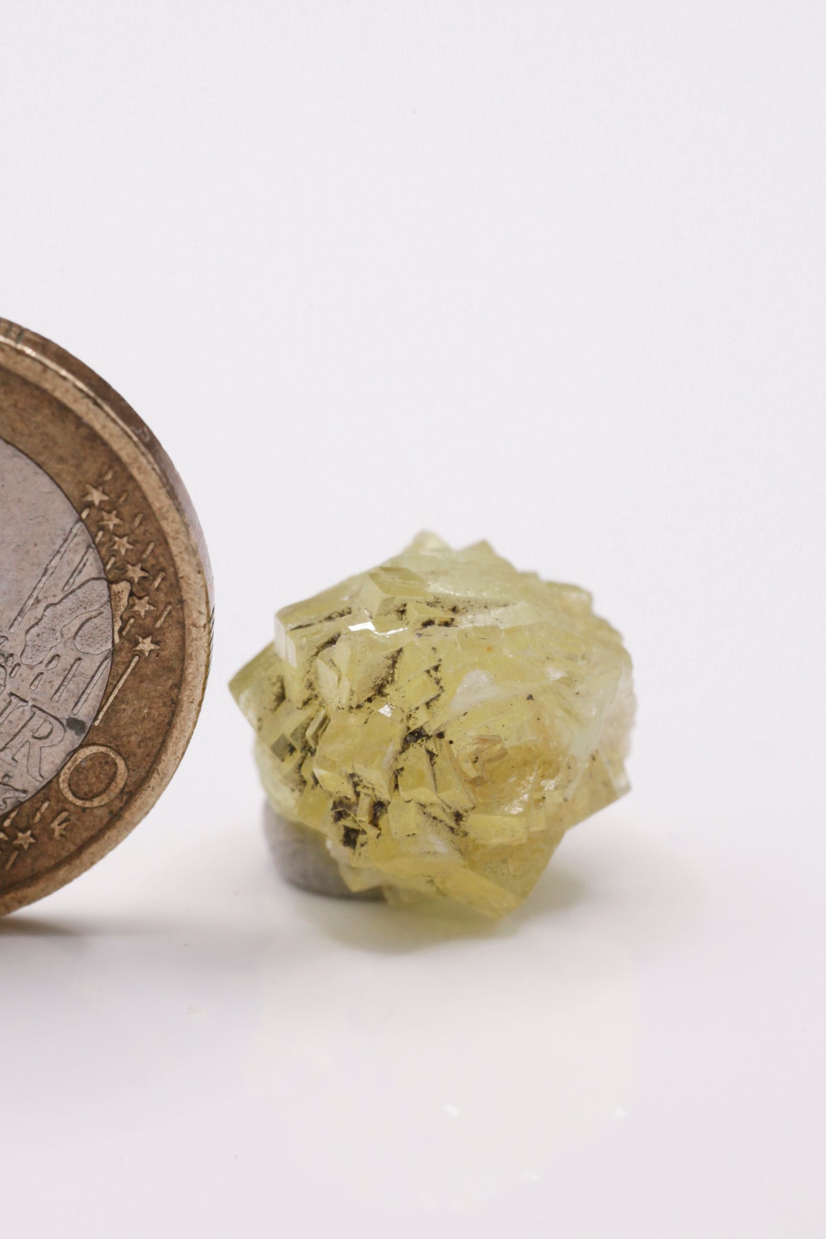 Prehnite - Mine Mineral Market : A121 Fast komplette Kugel eines gelben Kristallagglomerats mit etwas Graphit zwischen einigen Kristallspitzen. Die Kristallanordnung erinnert an eine Rose.