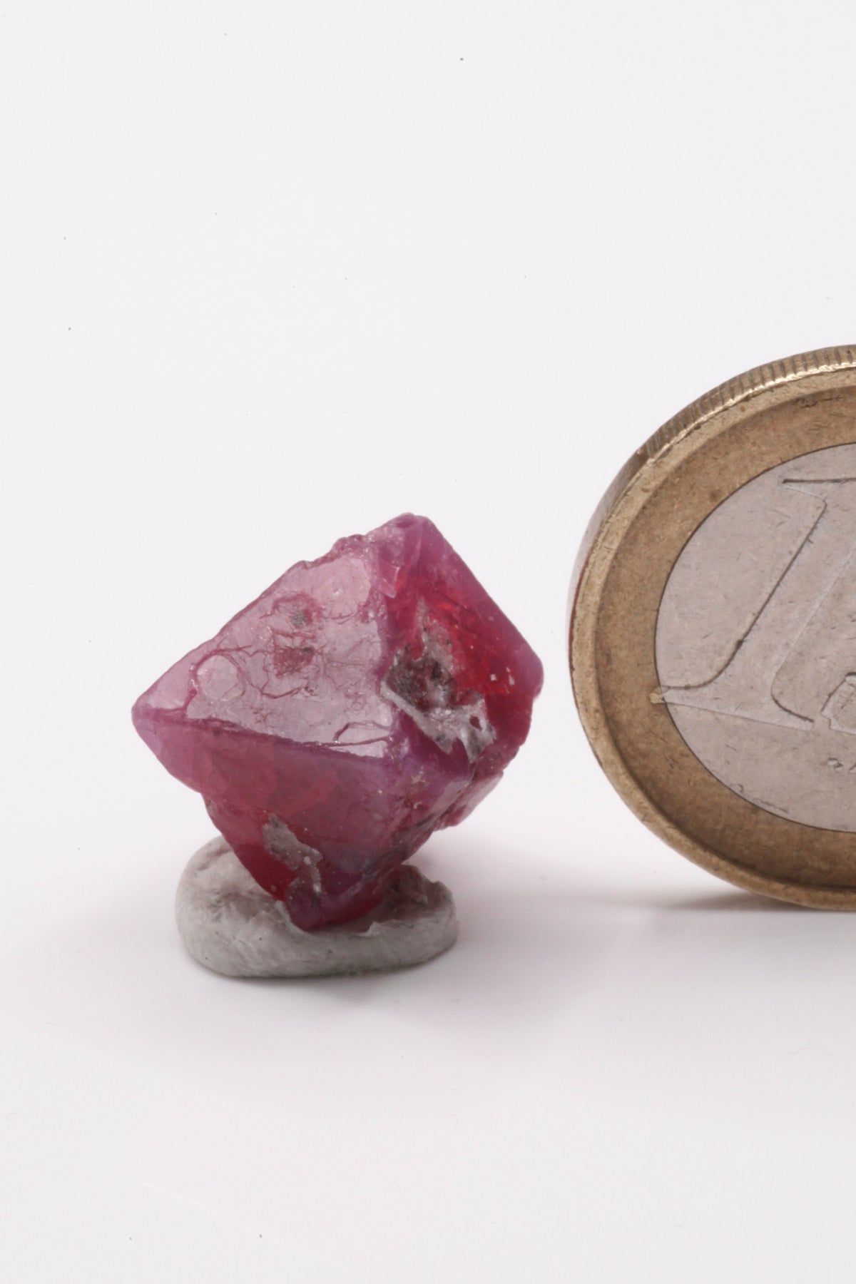 Spinel - Mine Mineral Market : A135 Der rot violette Oktaeder ist bis auf ein Drittel des Kristalls sehr gut ausgebildet. Die Flächen sind nahezu vollständig und haben einen guten Glanz.