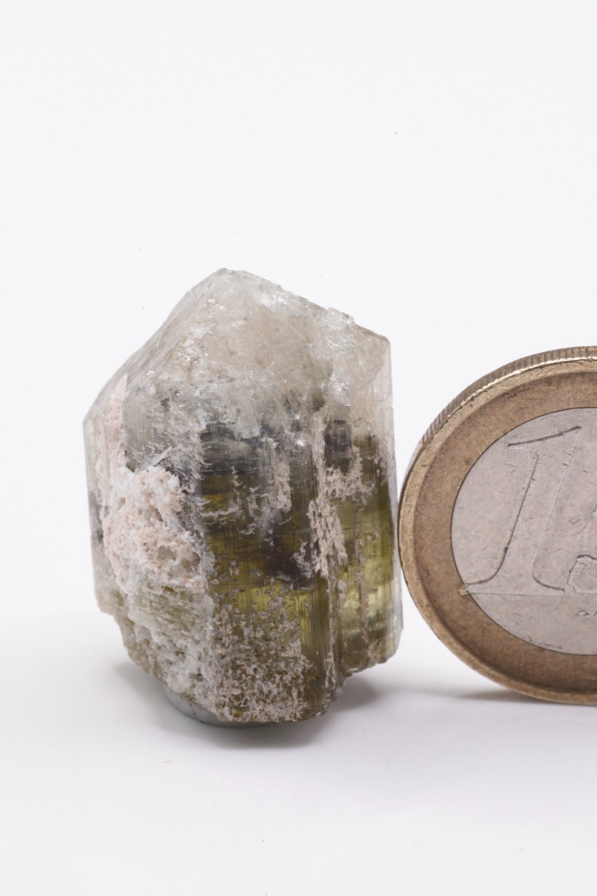 Kamana Tourmaline (Fe-Dravite)  - Mine Mineral Market :    A144 Dieser Dravit besitzt sehr gute Endflächen und drei deutliche Farbzonierungen von grüngelb über schwarz nach weiss. Außen etwas Matrix anhaftend.
