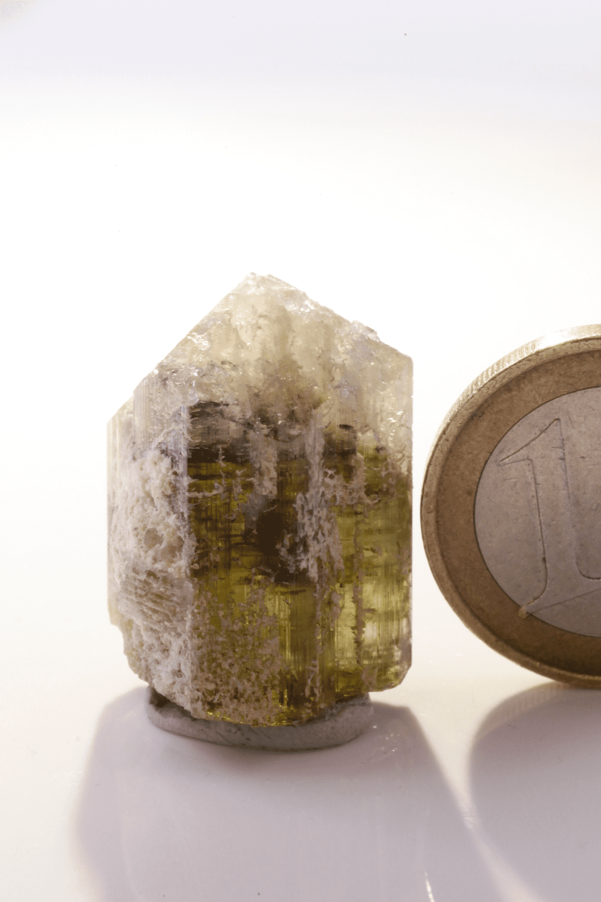Kamana Tourmaline (Fe-Dravite)  - Mine Mineral Market :    A144 Dieser Dravit besitzt sehr gute Endflächen und drei deutliche Farbzonierungen von grüngelb über schwarz nach weiss. Außen etwas Matrix anhaftend.