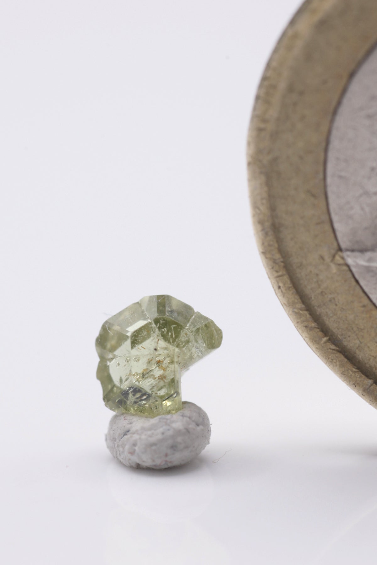 Chrysoberyl  - Mine Mineral Market :    A179 Ein kleiner aber feiner vollständiger zyklischer Drillingskristall von schöner grüngelber Farbe. Er zeigt sehr guten Glanz, ist klar und sogar scharfkantig ausgebildet, was auf einen sehr kurzen alluvialen Transport schließen lässt.