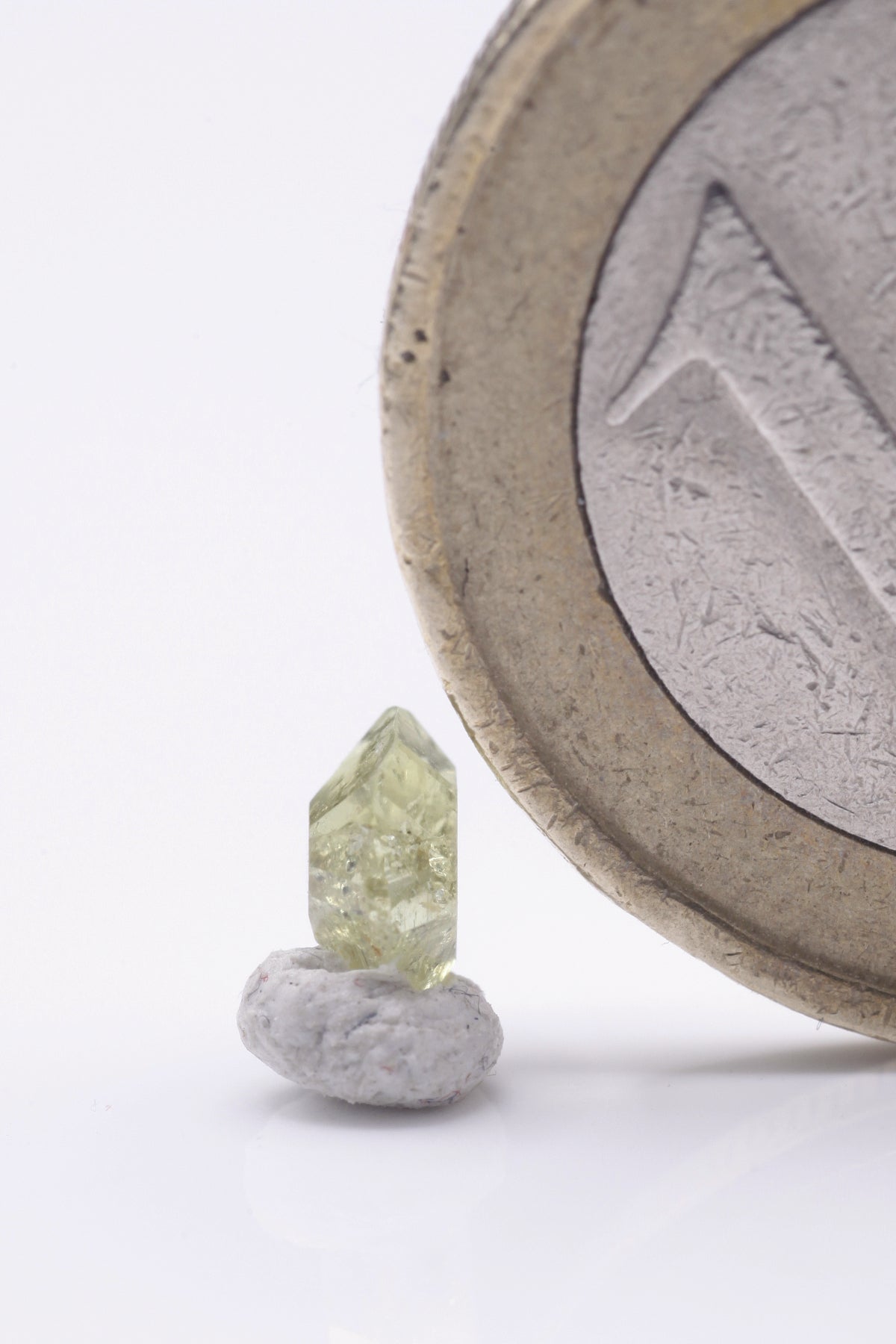 Chrysoberyl  - Mine Mineral Market :    A179 Ein kleiner aber feiner vollständiger zyklischer Drillingskristall von schöner grüngelber Farbe. Er zeigt sehr guten Glanz, ist klar und sogar scharfkantig ausgebildet, was auf einen sehr kurzen alluvialen Transport schließen lässt.