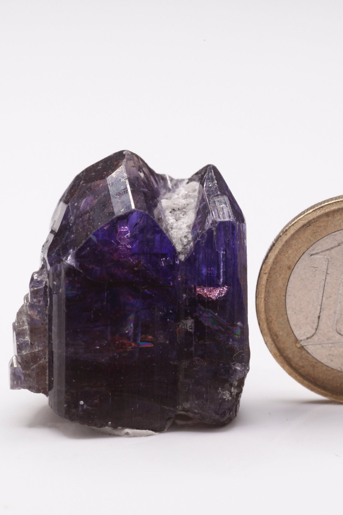 Tanzanite  - Mine Mineral Market :    A227 Wir erhielten ein Tansanitlot aus Altbeständen eines sightholders der seit 2015 geschlossenen Tanzanite One mining Gesellschaft. Daraus ein größerer dicklicher Kristall mit Doppelspitze von schöner tiefblauer Farbe mit komplexen und völlig intakten Endflächen, sehr schönem Farbspiel und sehr gutem Glanz. Zwischen den Spitzen befindet sich etwas Matrix, die wegpräpariert werden könnte, den Kristall in unserer Sicht jedoch interessanter und einzigartiger macht.