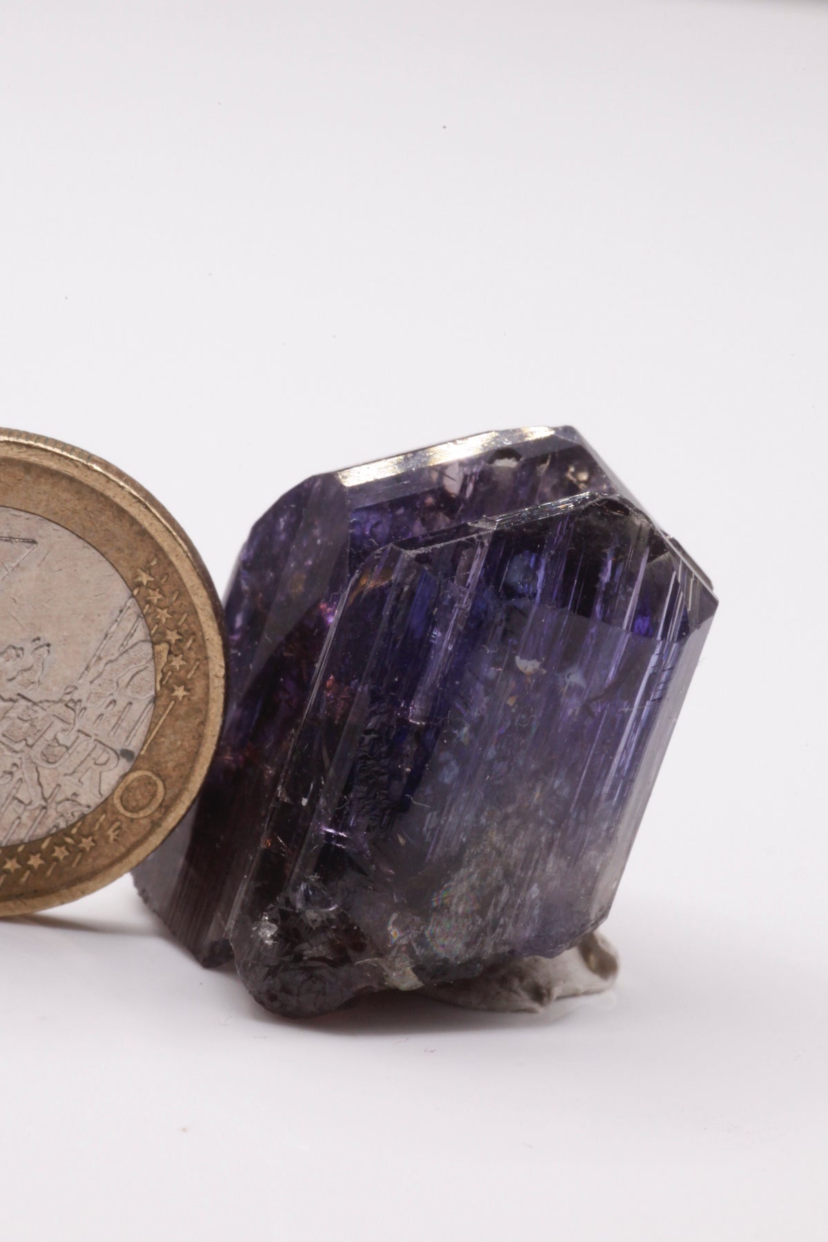 Tanzanite  - Mine Mineral Market :    A227 Wir erhielten ein Tansanitlot aus Altbeständen eines sightholders der seit 2015 geschlossenen Tanzanite One mining Gesellschaft. Daraus ein größerer dicklicher Kristall mit Doppelspitze von schöner tiefblauer Farbe mit komplexen und völlig intakten Endflächen, sehr schönem Farbspiel und sehr gutem Glanz. Zwischen den Spitzen befindet sich etwas Matrix, die wegpräpariert werden könnte, den Kristall in unserer Sicht jedoch interessanter und einzigartiger macht.