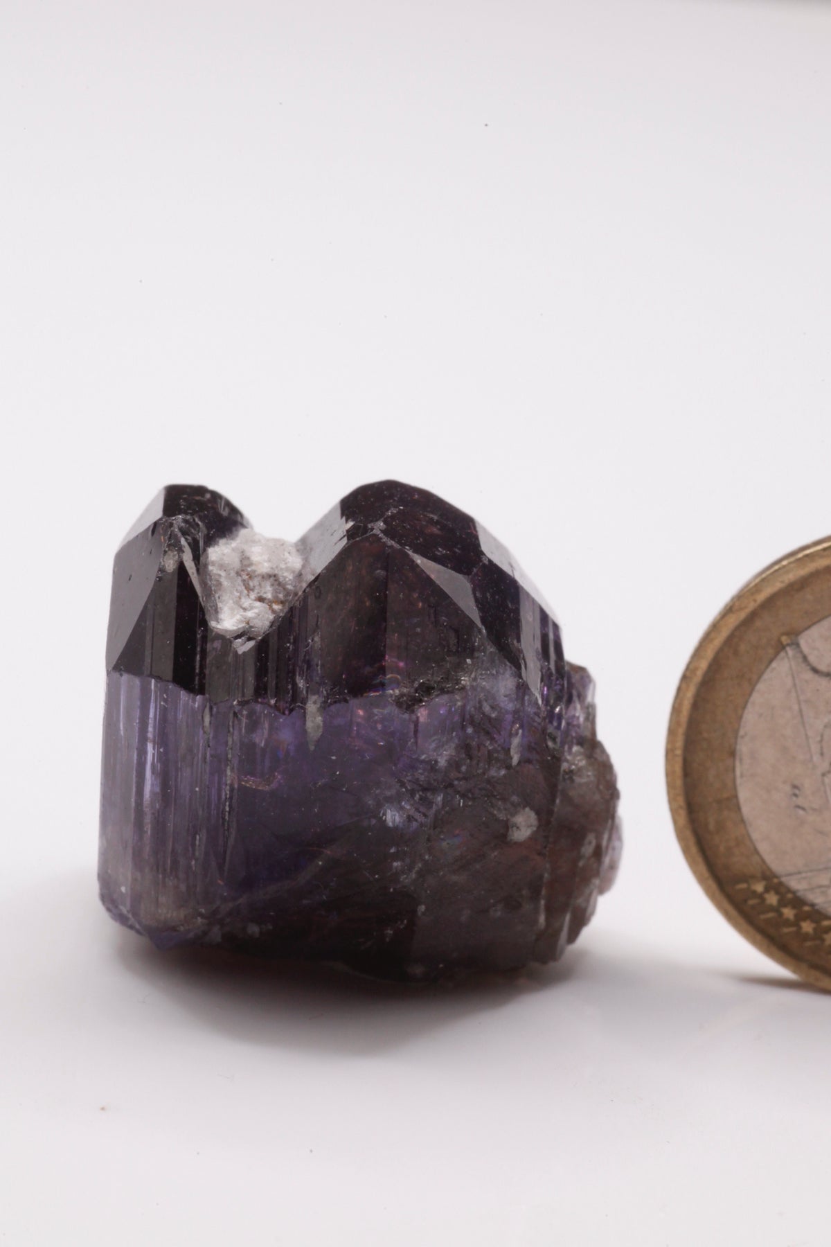 Tanzanite  - Mine Mineral Market :    A227 Wir erhielten ein Tansanitlot aus Altbeständen eines sightholders der seit 2015 geschlossenen Tanzanite One mining Gesellschaft. Daraus ein größerer dicklicher Kristall mit Doppelspitze von schöner tiefblauer Farbe mit komplexen und völlig intakten Endflächen, sehr schönem Farbspiel und sehr gutem Glanz. Zwischen den Spitzen befindet sich etwas Matrix, die wegpräpariert werden könnte, den Kristall in unserer Sicht jedoch interessanter und einzigartiger macht.