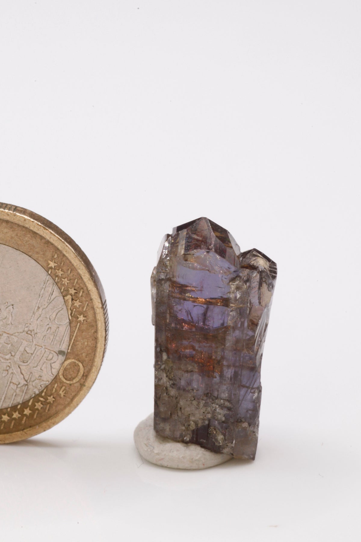 Tanzanite - Mine Mineral Market : A236 Kleinerer, teilweise facettierbarer Kristall mit deutlichem Pleochroismus. Bis auf eine kleine Ecke sind die beiden Spitzen vollständig und haben einen ausgezeichneten Glanz.