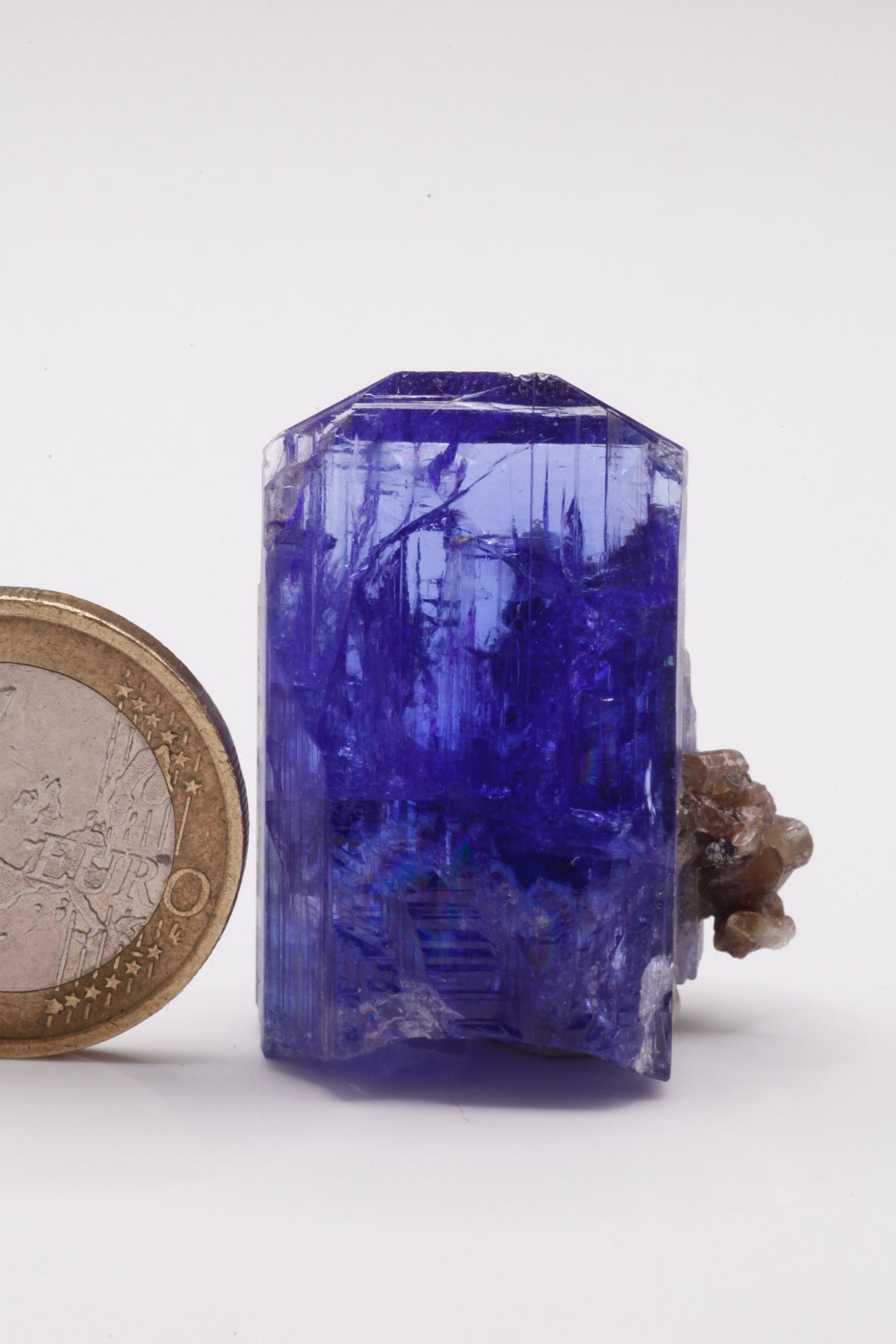 Tanzanite  - Mine Mineral Market :    A028 Ein größerer transparenter und unbeschädigter Kristall von schöner tiefblauer Farbe, mit etwas Matrix (Graphit & Diopsid) und sehr gutem Glanz.  