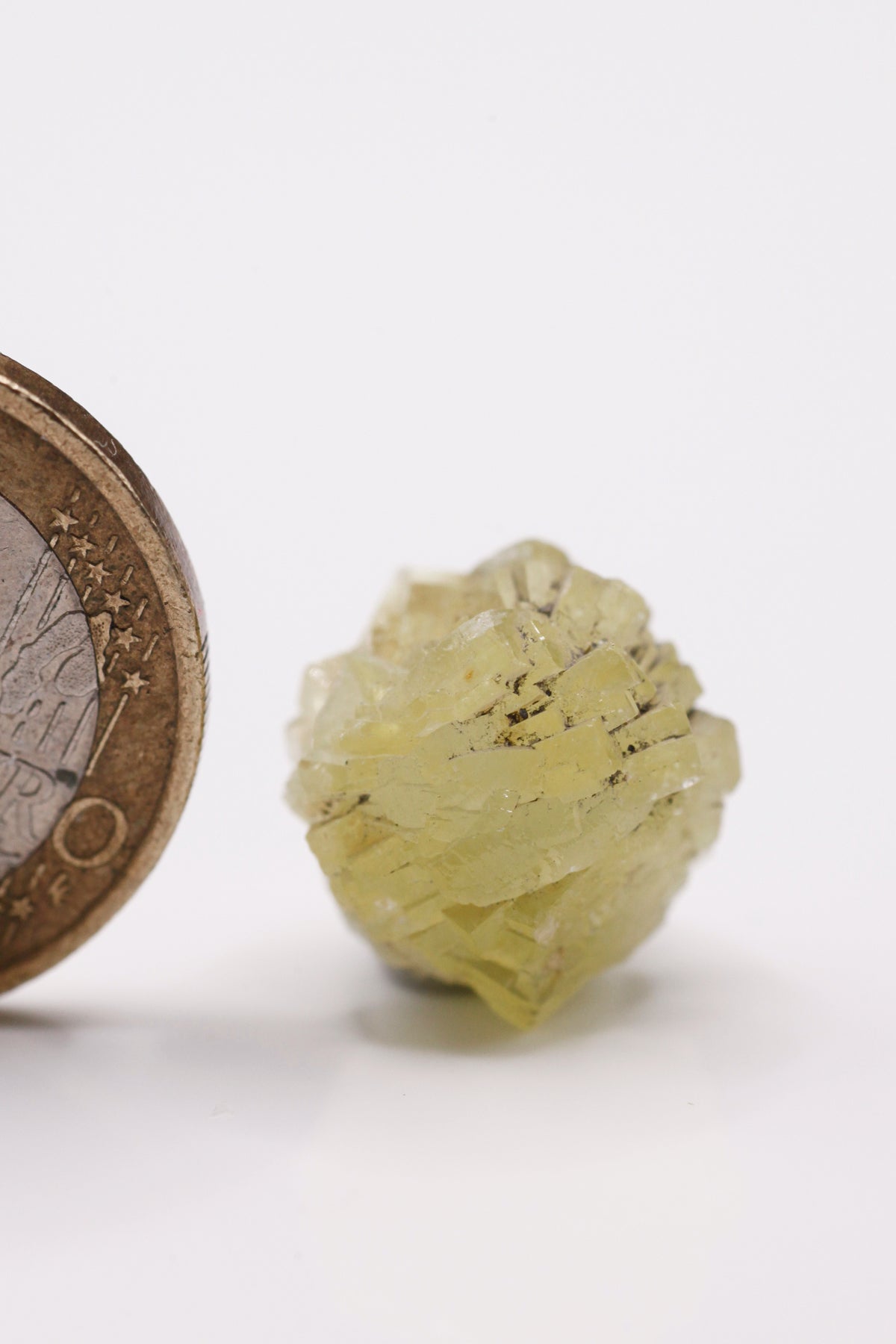 Prehnite  - Mine Mineral Market :    A121 Fast komplette Kugel eines gelben Kristallagglomerats mit etwas Graphit zwischen einigen Kristallspitzen. Die Kristallanordnung erinnert an eine Rose.  