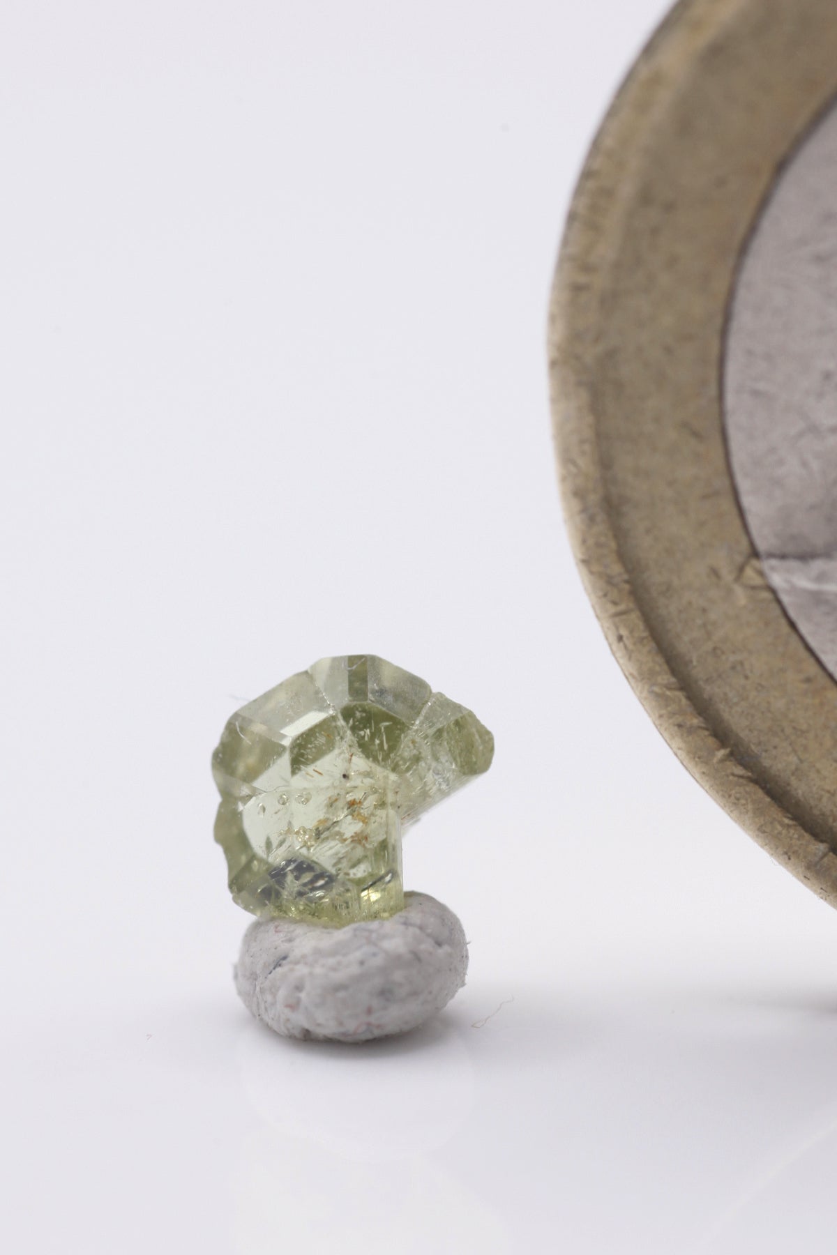 Chrysoberyl  - Mine Mineral Market :    A179 Ein kleiner aber feiner vollständiger zyklischer Drillingskristall von schöner grüngelber Farbe. Er zeigt sehr guten Glanz, ist klar und sogar scharfkantig ausgebildet, was auf einen sehr kurzen alluvialen Transport schließen lässt.  