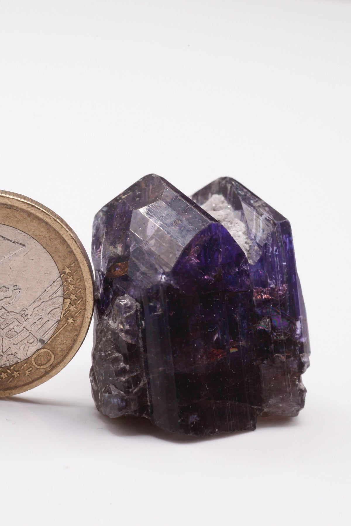 Tanzanite  - Mine Mineral Market :    A227 Wir erhielten ein Tansanitlot aus Altbeständen eines sightholders der seit 2015 geschlossenen Tanzanite One mining Gesellschaft. Daraus ein größerer dicklicher Kristall mit Doppelspitze von schöner tiefblauer Farbe mit komplexen und völlig intakten Endflächen, sehr schönem Farbspiel und sehr gutem Glanz. Zwischen den Spitzen befindet sich etwas Matrix, die wegpräpariert werden könnte, den Kristall in unserer Sicht jedoch interessanter und einzigartiger macht.  