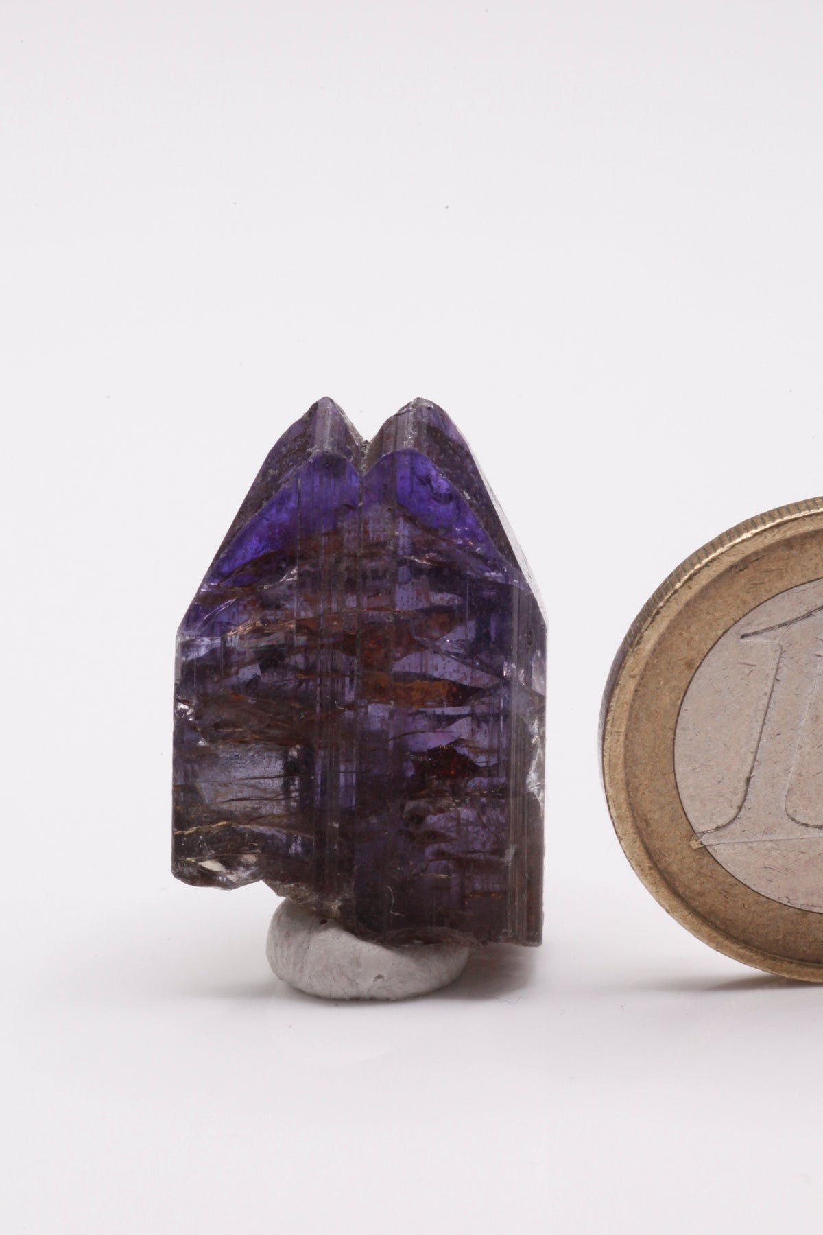 Tanzanite  - Mine Mineral Market :    A229 Wir erhielten ein Tansanitlot aus Altbeständen eines sightholders der seit 2015 geschlossenen Tanzanite One mining Gesellschaft. Hieraus ein zweifarbiger Doppelkristall mit hochinteressanter Farbzonierung: Während der größte untere Bereich unter polarisiertem Licht hellblau bzw. -rot gefärbt ist, zeigt die Spitze einen orientierten Farbstreifen von tintenblau nach violett.  