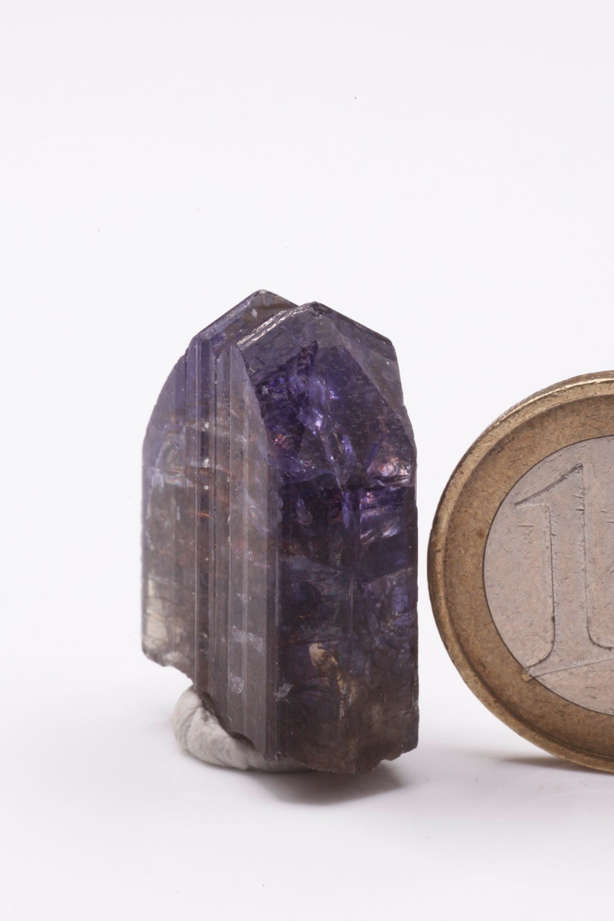 Tanzanite  - Mine Mineral Market :    A229 Wir erhielten ein Tansanitlot aus Altbeständen eines sightholders der seit 2015 geschlossenen Tanzanite One mining Gesellschaft. Hieraus ein zweifarbiger Doppelkristall mit hochinteressanter Farbzonierung: Während der größte untere Bereich unter polarisiertem Licht hellblau bzw. -rot gefärbt ist, zeigt die Spitze einen orientierten Farbstreifen von tintenblau nach violett.  