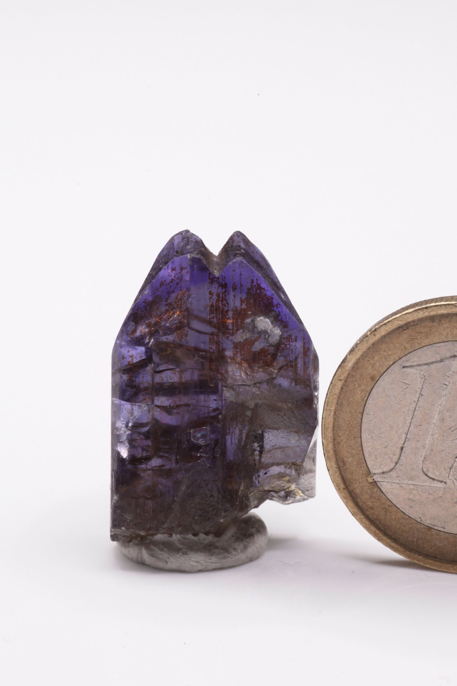 Tanzanite  - Mine Mineral Market :    A229 Wir erhielten ein Tansanitlot aus Altbeständen eines sightholders der seit 2015 geschlossenen Tanzanite One mining Gesellschaft. Hieraus ein zweifarbiger Doppelkristall mit hochinteressanter Farbzonierung: Während der größte untere Bereich unter polarisiertem Licht hellblau bzw. -rot gefärbt ist, zeigt die Spitze einen orientierten Farbstreifen von tintenblau nach violett.  