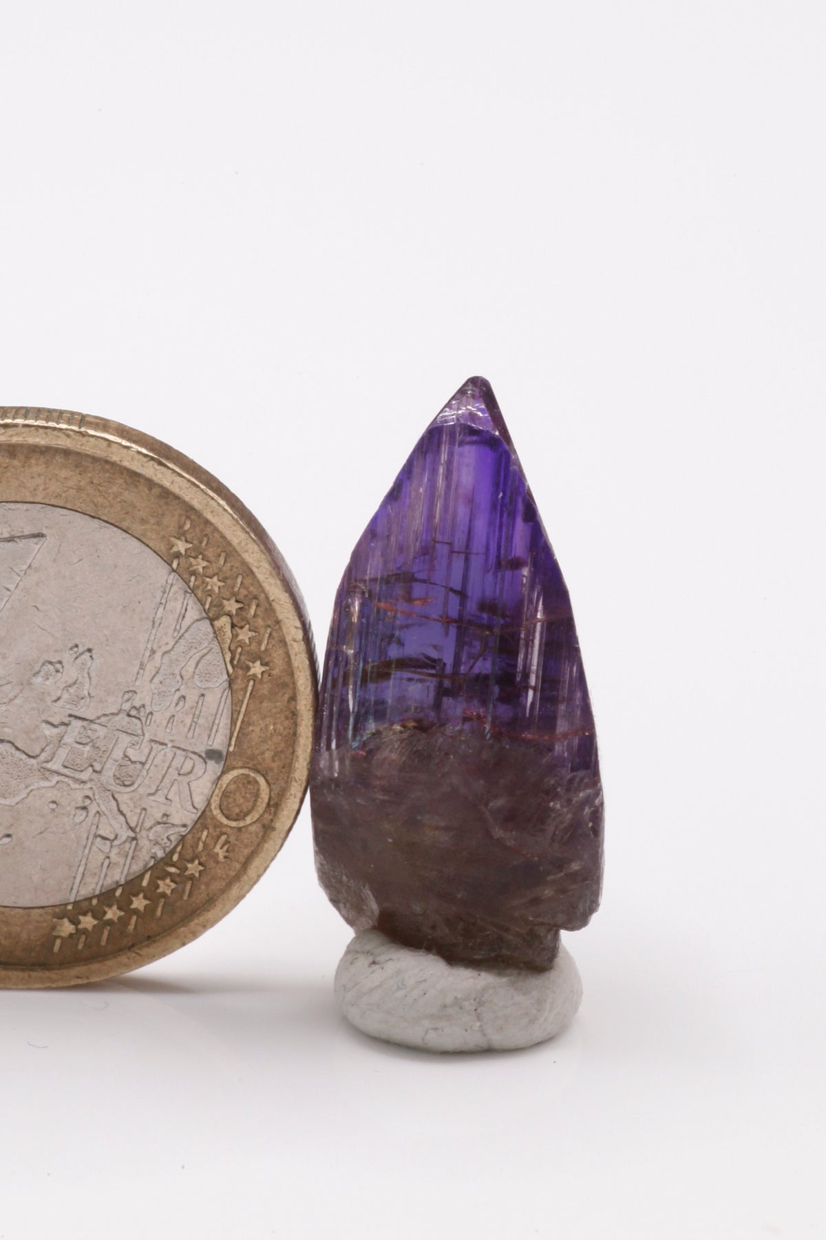 Tanzanite  - Mine Mineral Market :    A237 Bei seitlicher Betrachtung nahezu klarer Kristall der im polarisierten Licht je nach Betrachtungswinkel gelb, blau oder kräftig rotviolett erscheint. Der Tansanit hat keine Beschädigungen und besitzt einen sehr guten Glanz.  