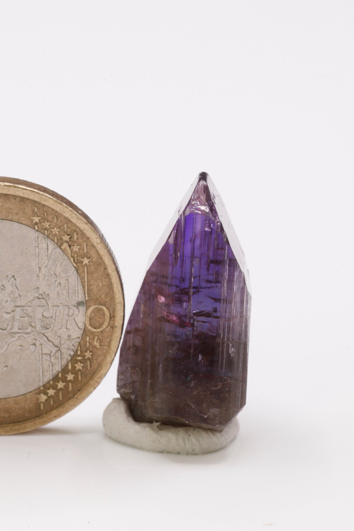 Tanzanite  - Mine Mineral Market :    A237 Bei seitlicher Betrachtung nahezu klarer Kristall der im polarisierten Licht je nach Betrachtungswinkel gelb, blau oder kräftig rotviolett erscheint. Der Tansanit hat keine Beschädigungen und besitzt einen sehr guten Glanz.  